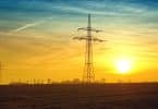 Brown Transmission Towers on Field during Sunset Landscape Photography