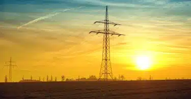 Brown Transmission Towers on Field during Sunset Landscape Photography