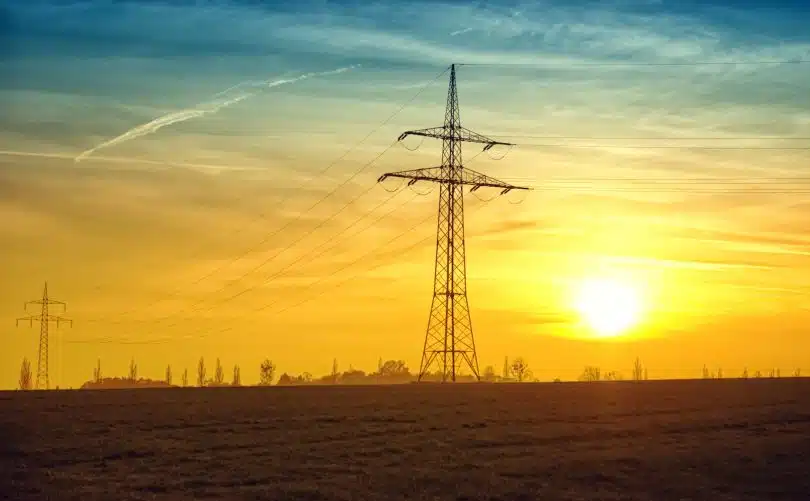 Brown Transmission Towers on Field during Sunset Landscape Photography