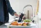 person holding stainless steel faucet