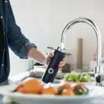 person holding stainless steel faucet