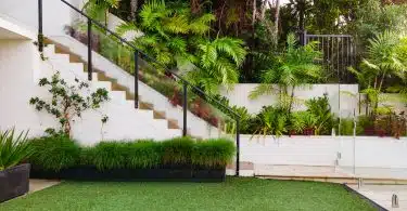 a white house with a green lawn and stairs